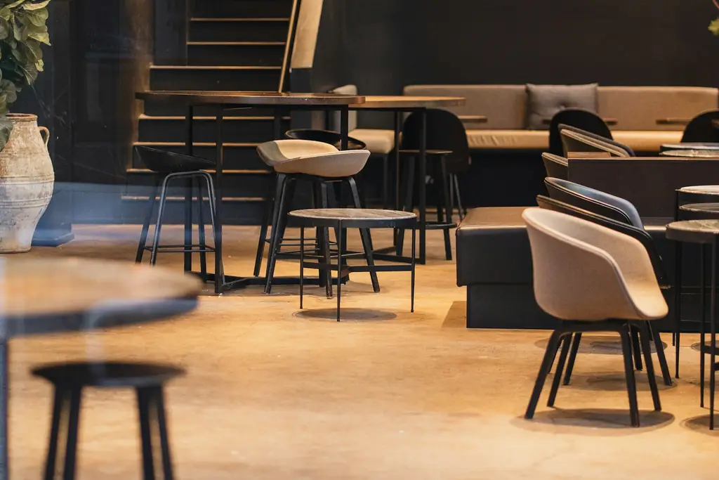 Warmly lit café interior with tables and stools