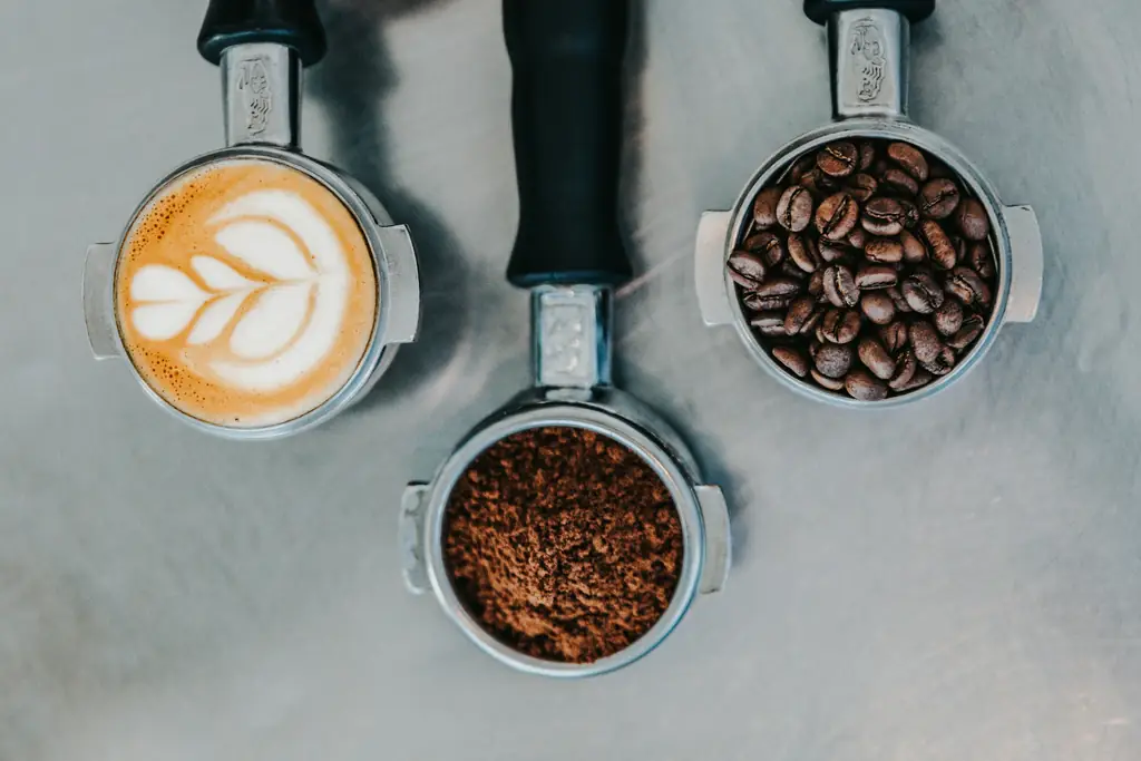 Flat lay of a latte, ground coffee and whole beans in portafilters